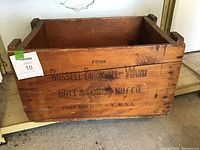 Front-side view of wooden crate showing company logo and text on the side panel