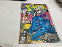Comic book featuring X-Men characters on cover in plastic sleeve on white surface.