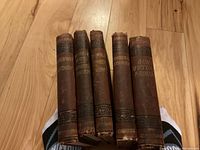 Five vintage Charles Dickens hardcover books showing spine titles and worn condition.