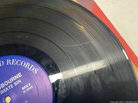 Close-up photo of purple label on vinyl record showing artist and album title