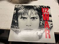 Close-up front cover of the U2 War vinyl record showing a boy's face and red text.