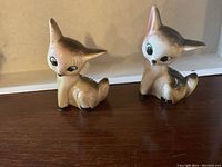 Pair of ceramic deer salt and pepper shakers front view on wooden surface