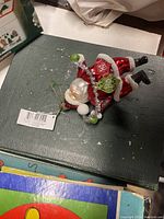 Santa Claus Christmas ornament lying on a book, showing colorful details and tag