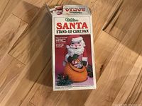 Front of the Wilton Santa stand-up cake pan box showing colorful decorated Santa cake image and branding.