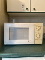 Closed view of Citizen microwave showing the front door with a window and two control dials on the right.