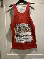 Full front view of red Budweiser tank top with large printed Budweiser beer label and details in white, gold, black.