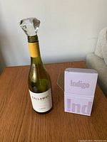 Wide shot showing crystal wine stopper inserted into a wine bottle with box on table, demonstrating size and packaging.