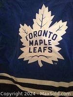 Close-up photo of the Toronto Maple Leafs logo on the blue fleece throw blanket.