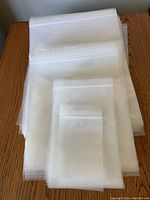 Stack of clear resealable plastic bags showing four distinct sizes from small to large stacked on each other.