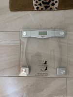 Top-down photo of Starfrit digital glass weight scale showing full platform, chrome corner supports, and central digital display