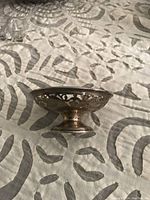 Side view of the small footed sterling silver candy dish showing the openwork side pattern and pedestal base.