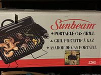 Photo of the retail box packaging of the Sunbeam portable gas grill with product image and branding.