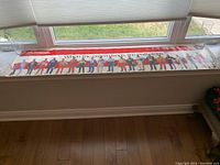 Wide shot showing entire horizontal poster with drivers and slogan, laid out on a window ledge.