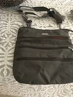 Front view of the Baggalini travel purse showing multiple zipped exterior pockets and adjustable shoulder strap.