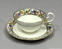 Side view of the vintage Aynsley floral teacup on saucer showing detailed floral pattern and gold trim.