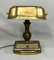 Vintage brass bankers lamp front view, showing patina and some wear on the shade and base