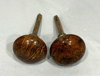Two vintage ceramic door knobs with brown swirl coloring shown lying flat with shafts visible.