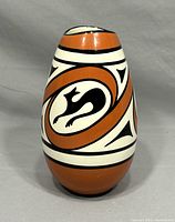 Front view of the tapered oval ceramic vase showing the terracotta and black animal motifs on a white background.