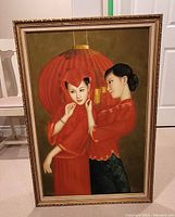 Framed full view of oil painting showing two women in traditional red dresses with a large red lantern behind them