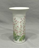 Front view of the white ceramic vase showing pink flowers and green foliage artwork.