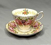 Side view of the Royal Albert Serena teacup on the matching saucer showing floral and gold accents