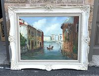 Full view of the vintage Venetian oil painting in white ornate frame, showing canal scene with gondola and architecture.