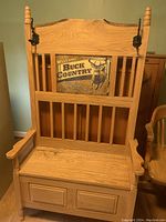 Solid wood wooden bench with slatted backrest, armrests, and storage compartment under the seat. Features decorative finials and panel detailing on base.