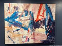 Close-up photo of a large abstract canvas with broad strokes in blue, red, purple, and beige colors.