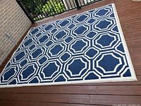 Full view of the navy and cream geometric patterned area rug on wood floor