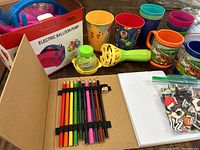Includes electric balloon pump in box, colored pencils in sketch book, plastic cups, bubble toys, and jibbitz accessories.