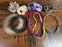 Photo of all hair accessories arranged on wooden surface, showing scrunchies, hair bands, claws, and gold headband.