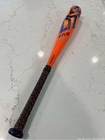 Full view of 26 inch Louisville aluminum baseball bat with orange barrel, blue black accents, and patterned grip.