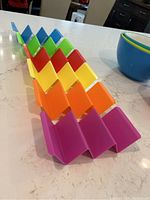 Photo showing six taco holders arranged in a row showing vibrant colors