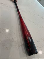 Photo showing the full length of the Rawlings 5150 alloy baseball bat with red and black color scheme.