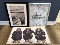 Two framed artworks pictured side by side: black and white canoe photograph and 'choose happiness' floral print.