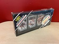 Front angle of sealed box showing visible hockey cards inside and branding.
