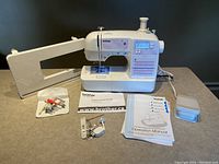 Machine on table with extension table attached, accessories laid out around it