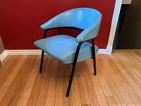 Front view of turquoise vinyl chair with curved backrest and black metal legs
