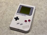 Front view of the Nintendo Game Boy showing the screen, buttons, and logo.