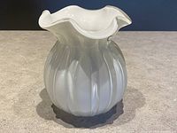 Side view of white cased glass vase showing smooth vertical ribs and ruffled rim