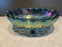 Side angled view of the oval carnival glass bowl showing its scalloped rim and iridescent color shifting finish.