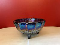 Front view of vintage carnival glass footed fruit bowl showing iridescent blue-green color and scalloped edge.