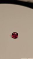 Close-up photo of a natural natural 1.04ct cushion cut ruby showing its deep red pink color and faceted cut.