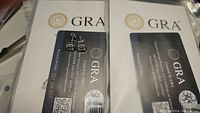 Front view of cushion cut moissanite earrings on GRA certification card showing screw back closure and design details