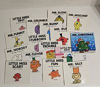 Top-down view of all 16 Little Miss and Mr. Men books showing various characters on the covers.