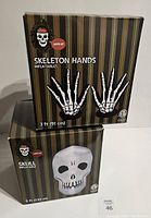 Box showing skeleton hands inflatable, 3 ft (91 cm) size, with skeleton hands graphic on front in black striped packaging.