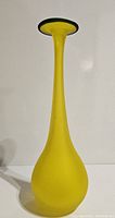Front view of the tall yellow frosted glass vase with blue lip on plain white background.