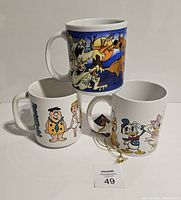 Three novelty mugs arranged with Scooby Doo mug on top, Flintstones and Disney mugs on bottom showing front designs.