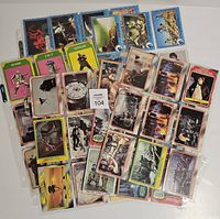 Photo showing a pile of mixed Star Wars trading cards with characters like Boba Fett and FX-7, various movie scenes, some cards in plastic sleeves.