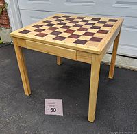 Front perspective view of the wooden chess table showing the full tabletop and one side drawer closed on four legs.